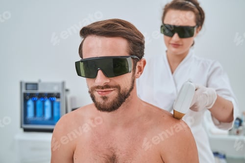 Preview: Male patient in protective eyeglasses during a cosmetic procedure