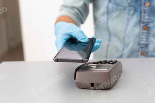 Preview: Contactless mobile payment. Payment terminal and smartphone in hands