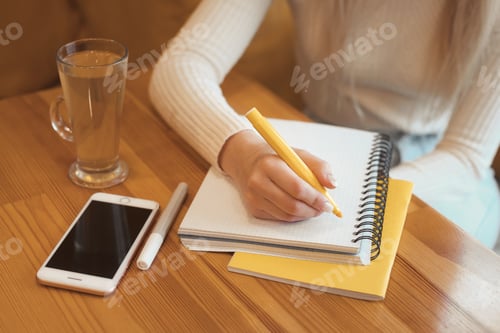 Preview: Young girl student drawning drawing with a marker in a empty notebook