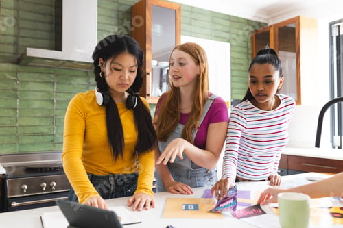 Preview: In kitchen, teen girls preparing school project, discussing ideas enthusiastically