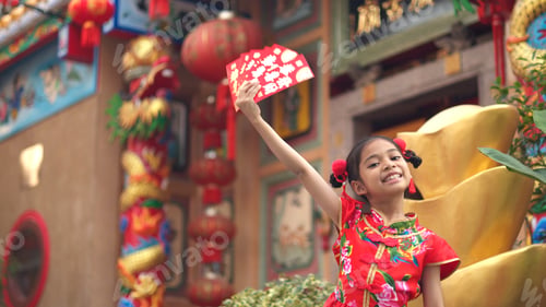 Preview: Asian girl wearing red traditional Chinese cheongsam decoration holding red envelopes in hand