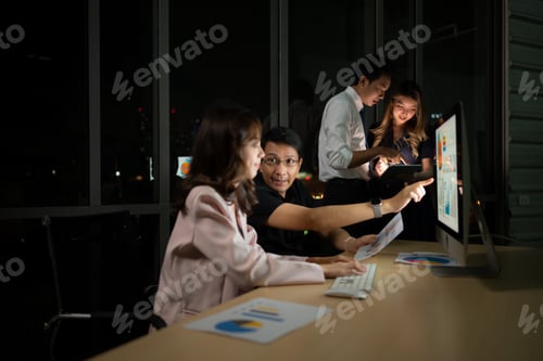 Preview: Group of business people working in office at night. Business concept.
