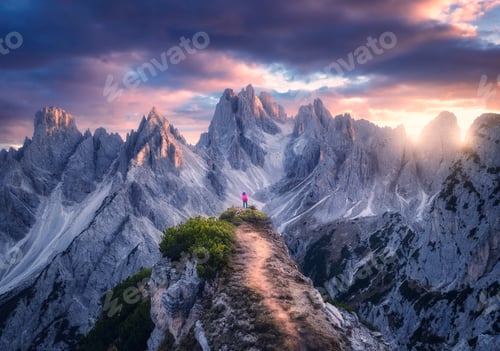 Preview: Aerial view of girl on the mountain peak and rocks at sunset