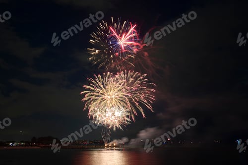 Visualização: Vista aérea de fogos de artifício brilhantes explodindo com luzes coloridas sobre a costa do mar