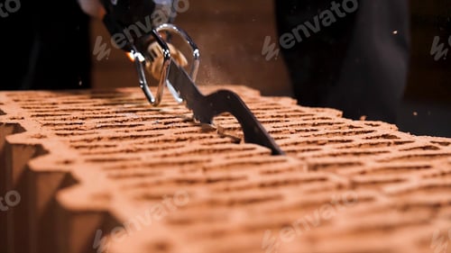 Preview: Close up of a man using electric saw to cut through a block in a cloud of dust. Stock footage