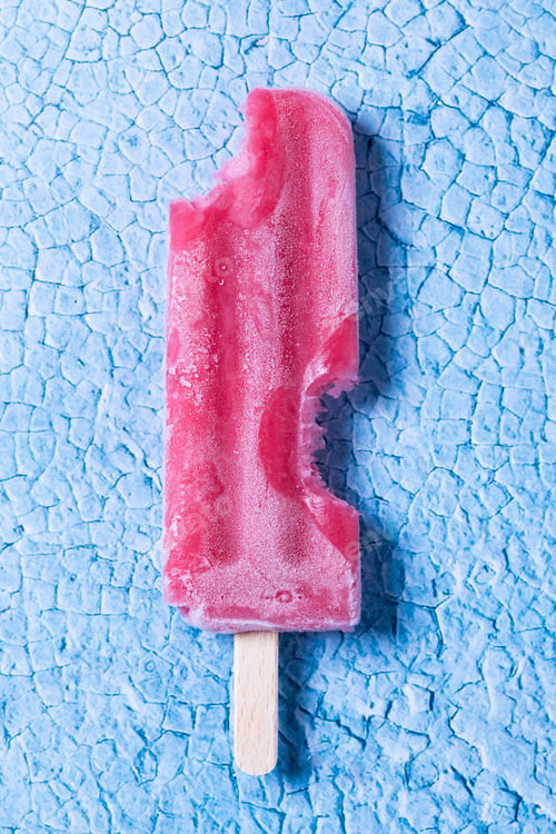 Preview: Red strawberry popsicles on blue background.