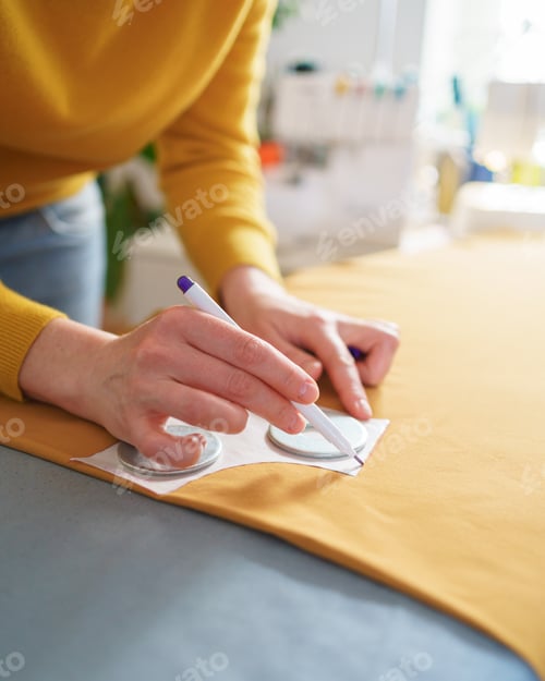 Preview: Female seamstress making sewing pattern while working at her creative workspace