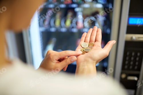 Preview: woman counting euro coins at vending machine
