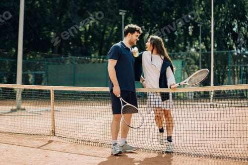 Preview: Happy couple enjoying tennis game and conversation