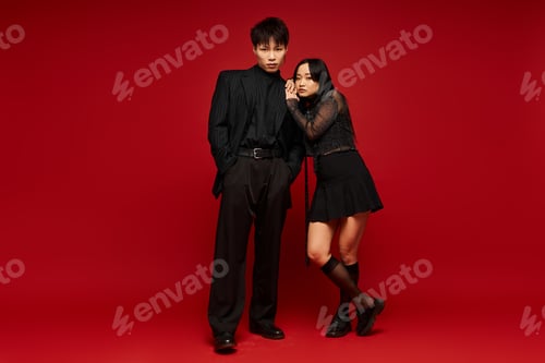 Preview: Stylish couple exuding love and charm in vibrant red backdrop during a fashion shoot