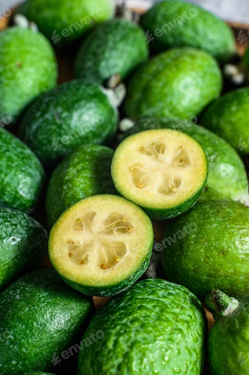 Preview: Green feijoa on a wooden board. Gray background. Top view. Close up