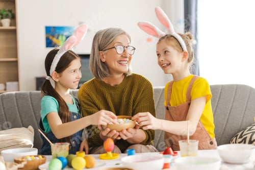 Preview: Grandchildren wearing bunny ears sharing easter sweets with grandmother