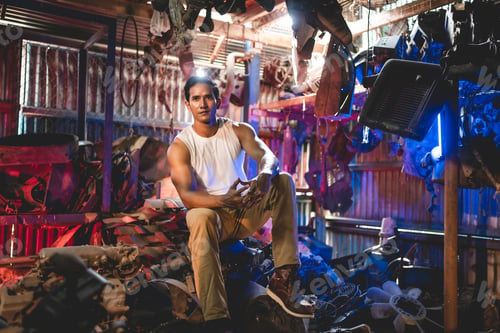 Preview: Young and handsome muscular and strop scrap material man in sleeveless shirt sitting on material