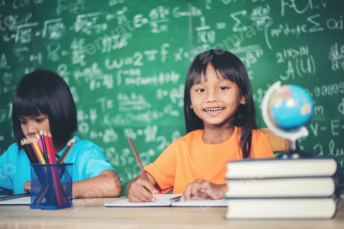 Preview: Two girl with crayon drawing at lesson in the classroom