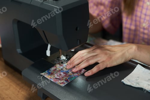 Preview: Young Adult Caucasian Woman Sewing Fabric with Sewing Machine Indoors