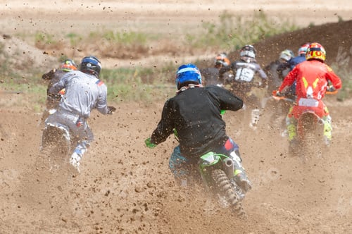 Preview: Unrecognized athletes riding a sports motorbike racing fast on a motocross track field. Challenge