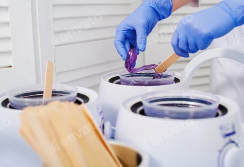 Preview: Girl beautician stirs the paste for shugaring close-up