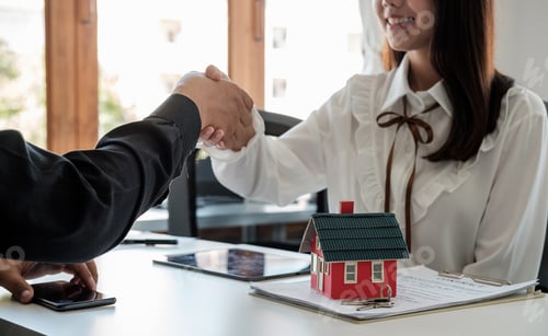Preview: Estate agent and customer shaking hands after fafter signing contract about home insurance and