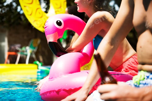 Preview: A diverse group of friends enjoying summer time by the pool with inflatable floats