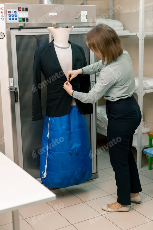 Preview: housekeeping worker opens puts jacket on mannequin for ironing clothes in laundry room