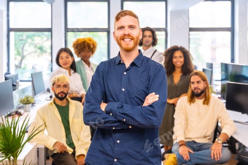 Preview: Manager standing proud surrounded by his team in a coworking