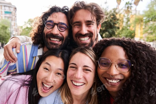 Preview: Close up portrait of group of multicultural friends looking at camera cheerfully with heads together