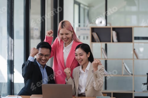 Preview: Excited happy business people celebrating together after hearing the good news