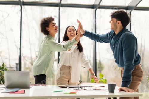 Preview: Multicultural Team Of Colleagues Giving High Five Celebrating Success Indoor