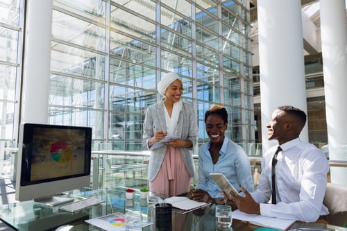 Preview: Male and females executives interacting with each other at desk