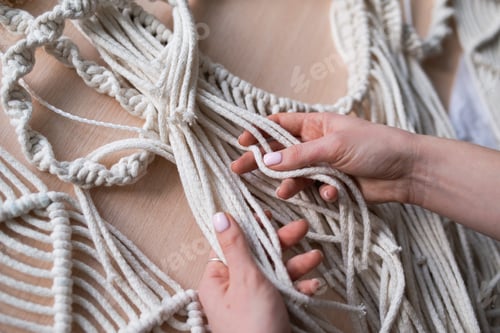 Preview: Woman weaves home decor from cotton thread macrame. Handmade in macrame technique.