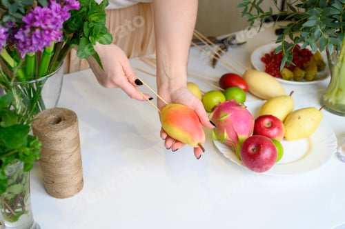 Preview: Woman Prepares Fruit Skewers for Healthy Snack