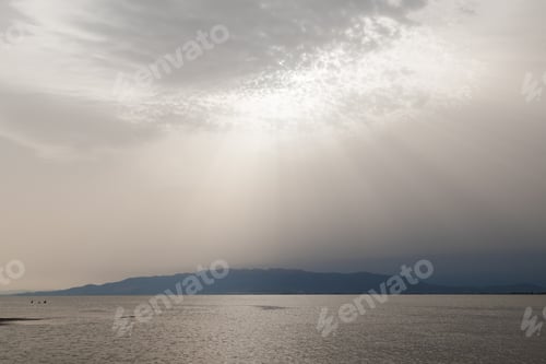 Preview: Sunbeams piercing through clouds over ebro delta