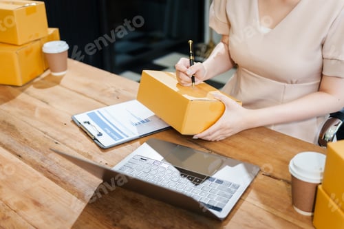 Preview: Two young female entrepreneurs work together in warehouse with parcel boxes, wooden tables,shelves