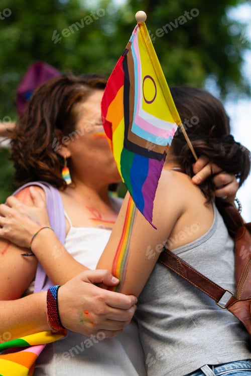 Preview: Two women kissing and holding intersex-inclusive progress pride flag at pride parade