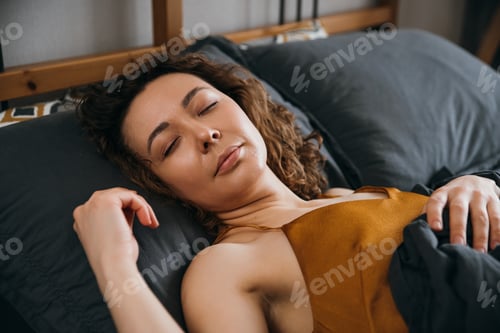 Preview: Middle-aged woman in peaceful sleep in calm bedroom