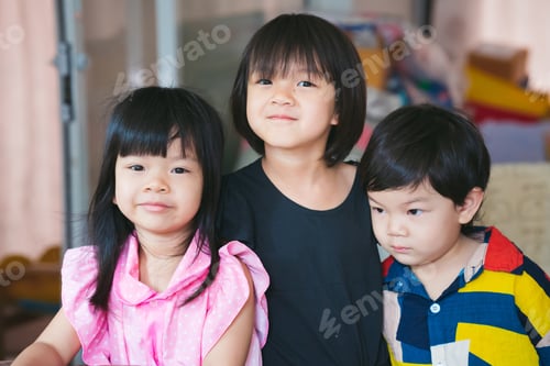 Preview: Three sibling held a photo together. Asian cute girl smiles sweetly.