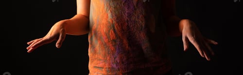 Preview: cropped view of woman with orange colorful holi paint powder on body and clothes isolated on black,