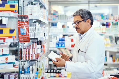 Preview: Shot of a mature pharmacist using a digital tablet while working in a chemist