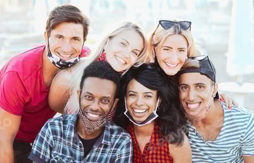 Preview: Group of multiracial friends taking a picture while focusing the camera and smiling with face mask