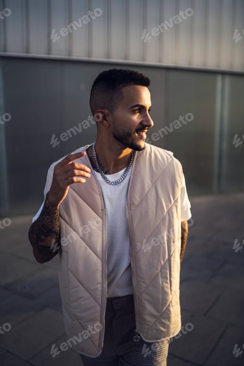 Preview: Vertical shot of a young cool male with a street style outfit smiling