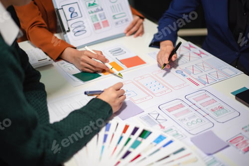 Preview: Close up view of UI developer team brainstorming on their project with laptop, smartphone