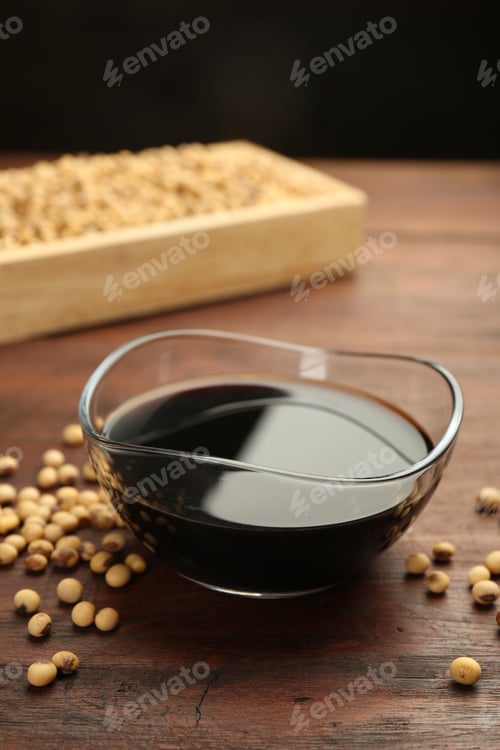 Preview: Soy sauce in bowl and soybeans on wooden table