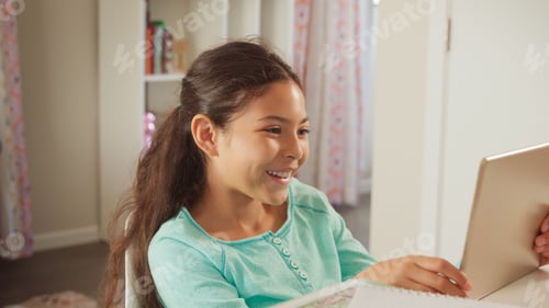 Preview: Smiling Young Girl Sitting At Desk In Bedroom At Home Using Digital Tablet