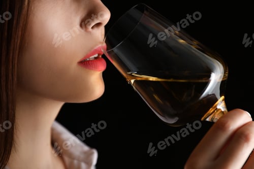 Preview: Young woman with glass of luxury white wine on black background, closeup view