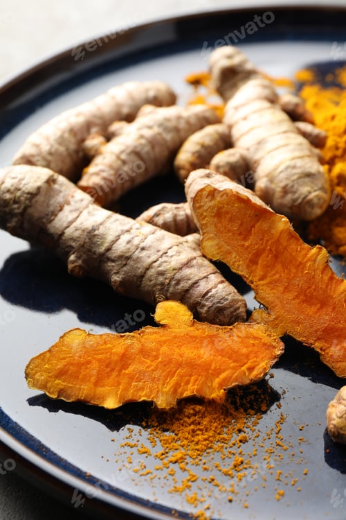 Preview: Aromatic turmeric powder and fresh roots on table, closeup