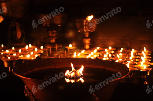 Preview: Butter lamps with flames near Bodhnath stupa in Kathmandu, Nepal