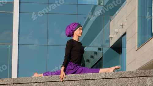Preview: Young calm Muslim lady in hijab islamic arab female indian woman girl yogi sitting on twine outdoors