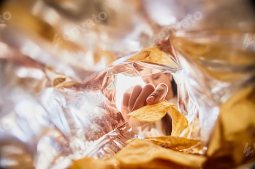 Preview: Young Woman Reaching into Snack Bag and Grabbing Tortilla Chips