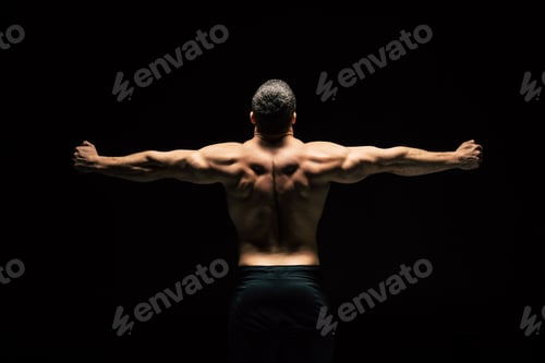 Preview: back view of shirtless sportive man showing muscles isolated on black