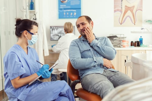 Preview: Stomatologist nurse explaining medical procedure to sick patient